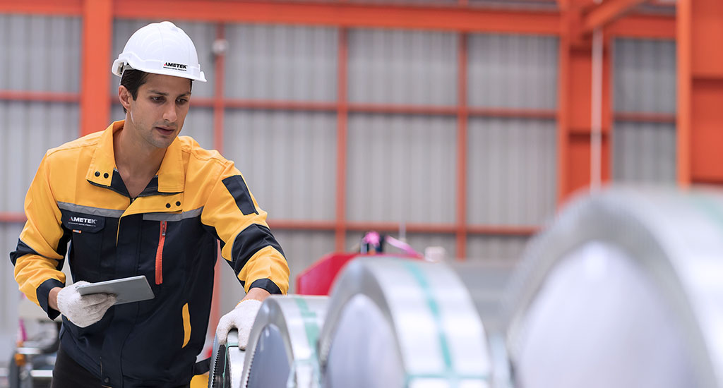 A worker inspecting the metal strip product manufactured at AMETEK SMP Wallingford plant